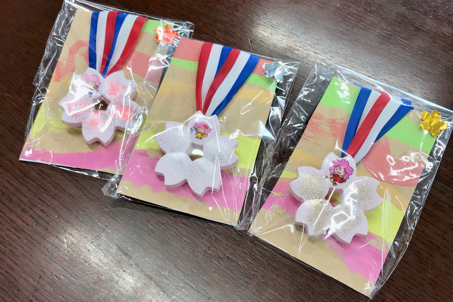 1位から3位までの東京都立多摩桜の丘学園(特別支援学校)の子どもたちが作ったメダルが授与
