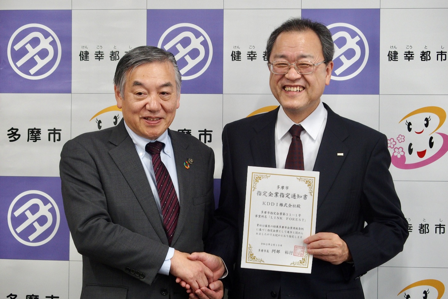 （左から）阿部裕行多摩市長とKDDI株式会社・代表取締役会長 田中孝司さん