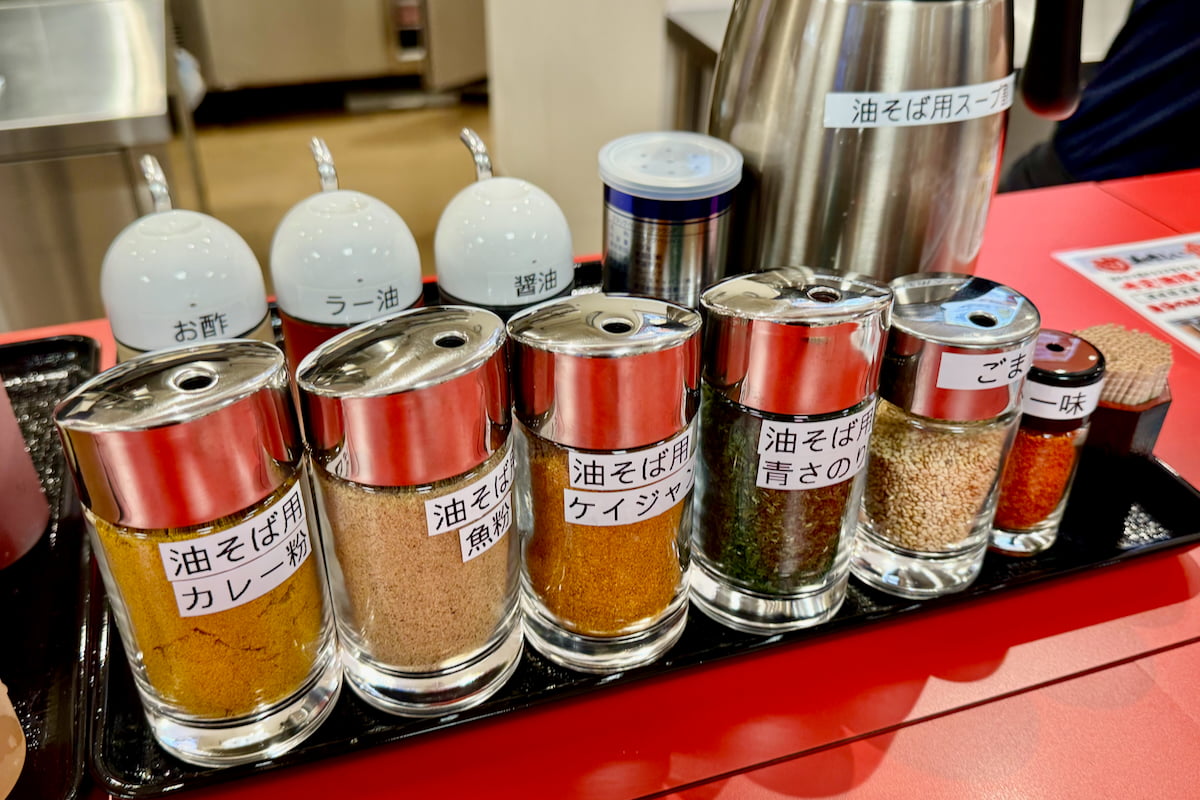 注文するカウンターには油そば用の魚粉やカレー粉、ケイジャンなどの味変調味料が並びま